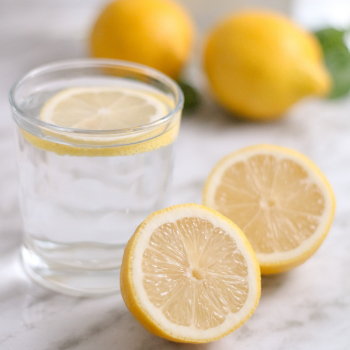 Glass of room temperature water with lemon to support collagen production and repair.